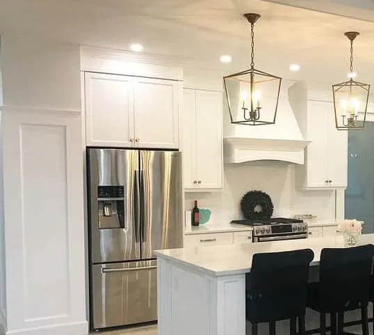 Detail of painted kitchen cabinetry, crown trim and range hood