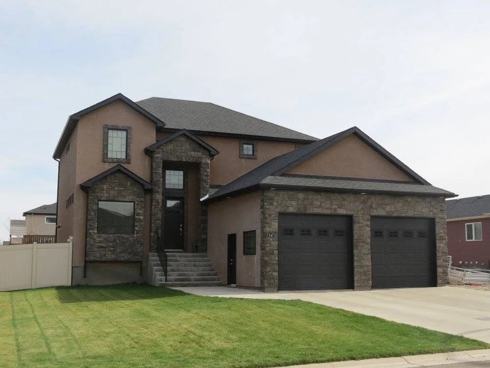 Completed two-storey home with warm exterior colours, stone accents and a landscaped front lawn