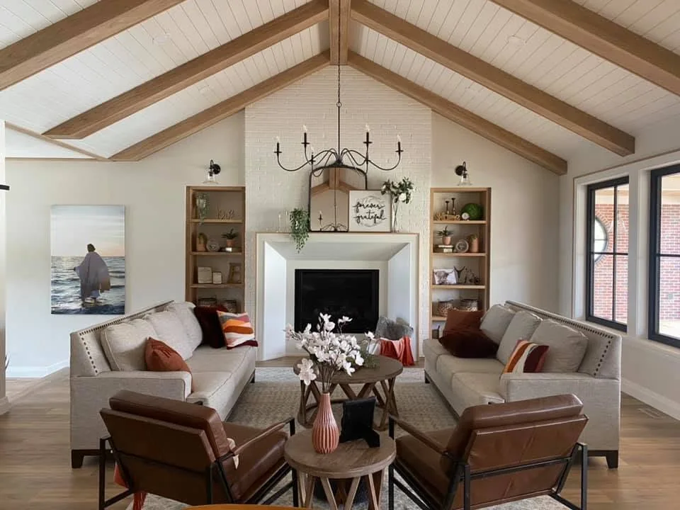 Furnished living room with natural timber ceiling beams, a fireplace and built-in shelving