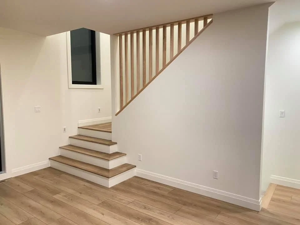 Light timber staircase with white risers and a vertical timber balustrade
