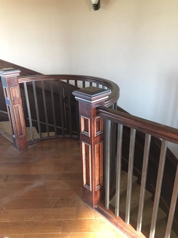 Curved timber balustrade with detailed newel posts and metal spindles