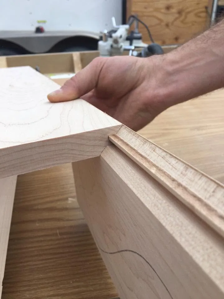 Hands checking the fit of a timber joinery detail