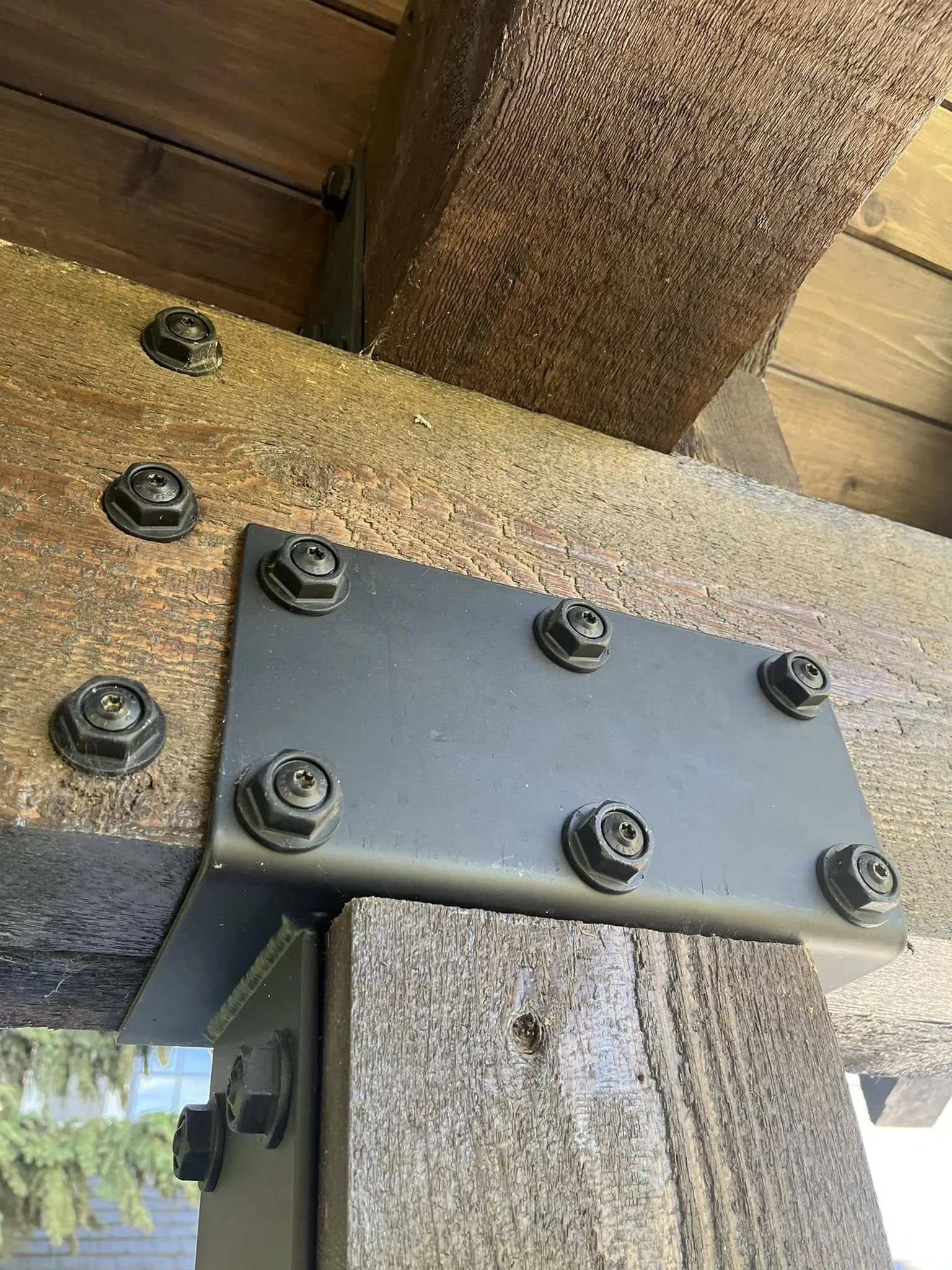 Close view of a timber connection with a metal plate and bolts