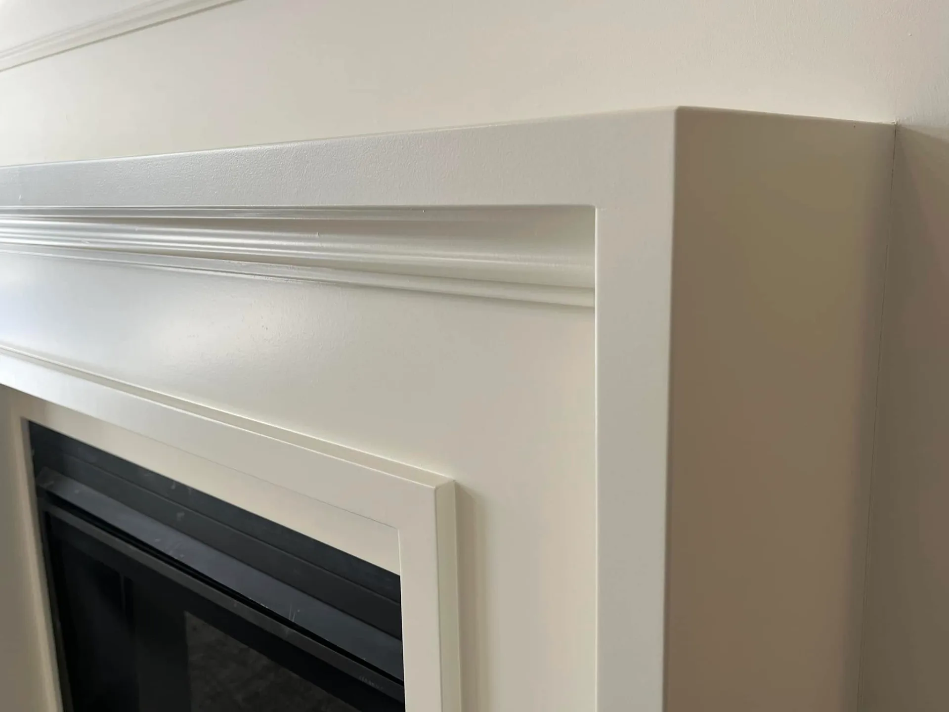Close view of the painted fireplace mantel and layered trim