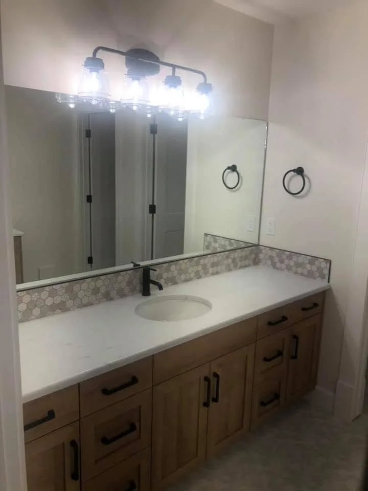 Wood vanity with black hardware and a hexagon tile backsplash